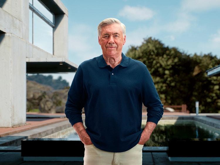 Carlo Ancelotti in piedi all’aperto davanti a una casa