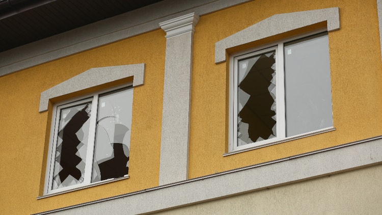 Immagine di una casa con i vetri delle finestre rotti