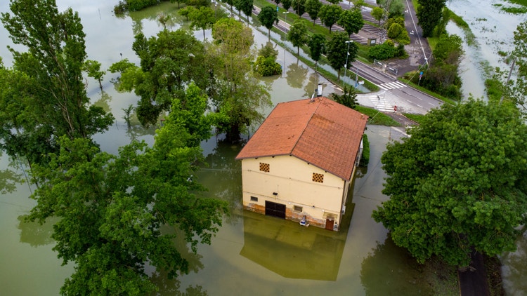 Veduta aerea di una casa isolata circondata dall&#39;acqua a causa di un&#39;alluvione in una zona rurale.