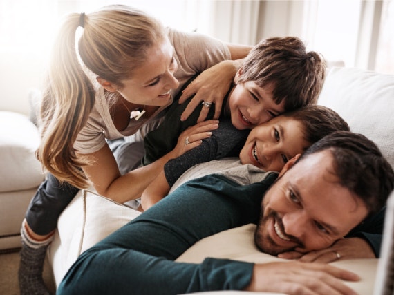 Famiglia con due bambini che gioca e ride insieme