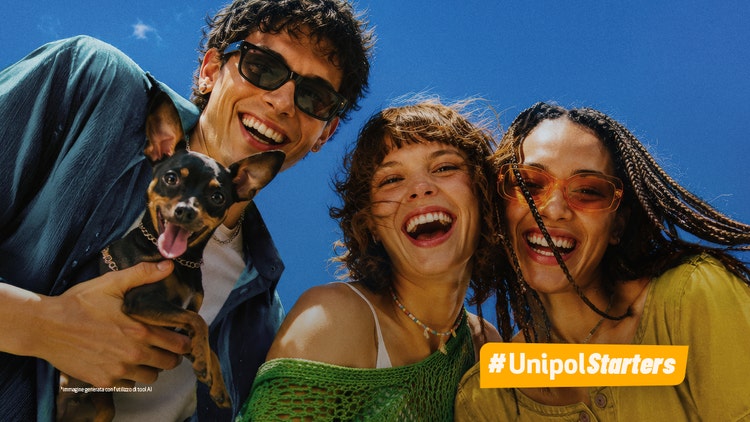 Tre giovani sorridenti con un cagnolino sotto un cielo blu brillante. Logo #UnipolStarters in basso a sinistra.