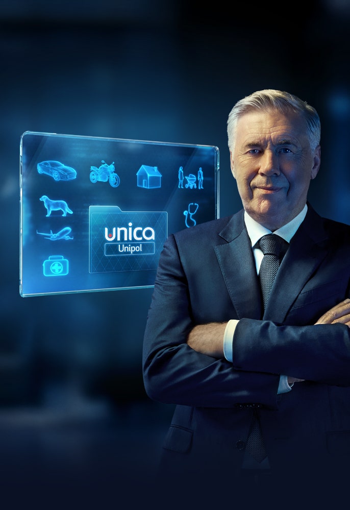 Carlo Ancelotti in giacca e cravatta a braccia conserte accanto a uno schermo olografico blu con icone Unipol.